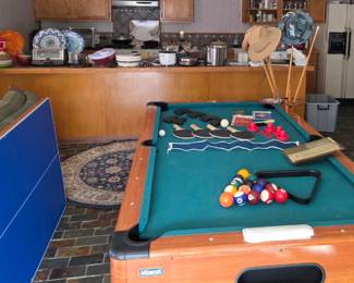 Pool table with top that is reversible to play table hockey and ping pong all accessories are included.