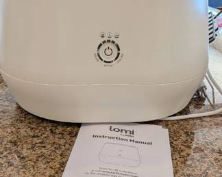 Lomi, an electric kitchen composter and food recycler designed by the company Pela. It’s a countertop appliance that uses heat, abrasion, and oxygen to break down food scraps (and some Lomi-approved bioplastics) into a nutrient-rich "dirt" that can be added to plants or your garden.