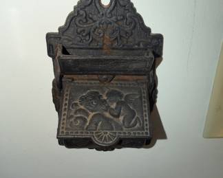vintage cast iron match holder features a detailed Venus and Cupid design