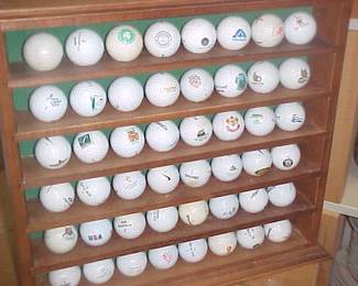 Collectors golf balls and wooden rack (sold individually).