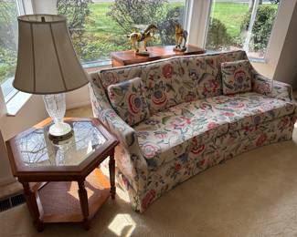 Curved low-profile couch and hexagon side table with cane tier and glass top 