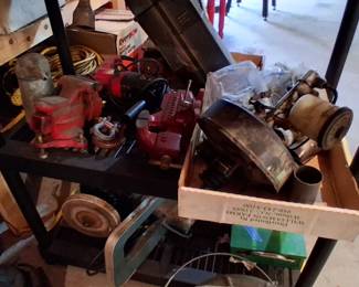 a variety of automotive or machinery parts, including a red metal vice and a carburator assembly