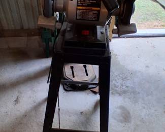  Craftsman 6-inch bench grinder mounted on a pedestal stand with a built-in work light. 