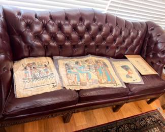 Egyptian papyrus paintings on tufted leather Chesterfield sofa