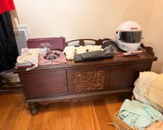 Carved cedar hope chest with Simpson racing helmet and linens