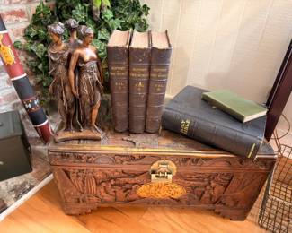 Carved wood camphor chest, bronze Three Graces statue, antique books