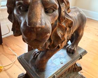 Large carved wooden lion statue on pedestal
