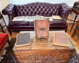 Burgundy leather Chesterfield sofa with carved wood chest