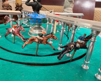 Mechanical horse race game detail with jockey figurines