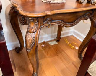 Carved wood accent table with claw feet