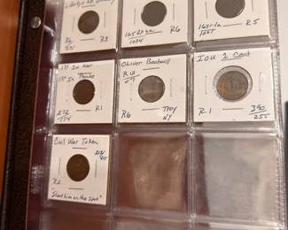 Collectible coin album with labeled holders including Civil War token