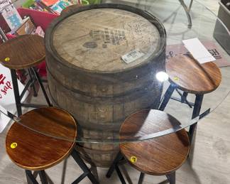 Rustic whiskey barrel bistro table topped with a circular glass surface.