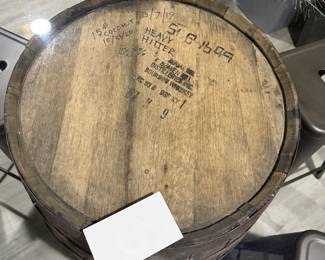 Rustic whiskey barrel bistro table topped with a circular glass surface.
