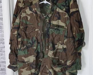  US Army M-65 field jacket in a woodland camouflage pattern featuring a zipper closure and four front pockets