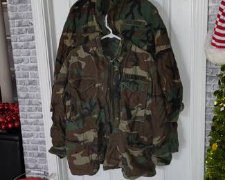  US Army M-65 field jacket in a woodland camouflage pattern featuring a zipper closure and four front pockets