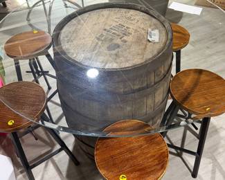 Rustic whiskey barrel bistro table topped with a circular glass surface.
