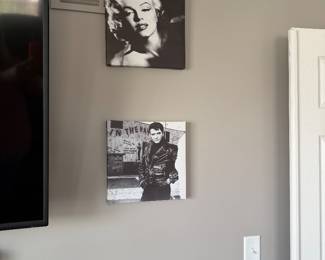 black and white canvas art prints displayed on a wall - a portrait of Marilyn Monroe & Elvis Presley in a leather jacket, a scene from his 1964 film Roustabout. 