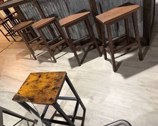  industrial-style backless bar stools with rustic wood seats and dark metal legs.