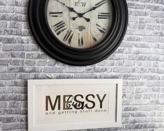 black wall clock featuring Roman numerals and a distressed white face