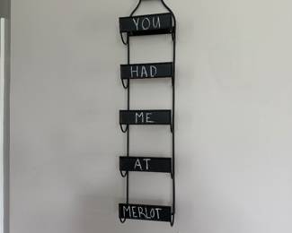 wall-mounted metal wine rack, featuring five slots for bottles 