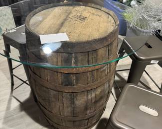 Rustic whiskey barrel bistro table topped with a circular glass surface.