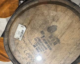 Rustic whiskey barrel bistro table topped with a circular glass surface.