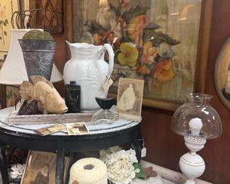 white pitcher, candlesticks, framed floral art, table