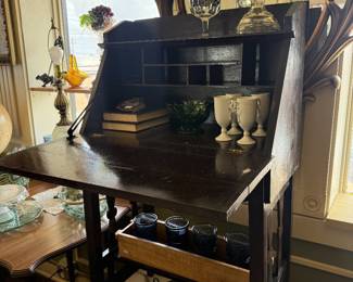 antique drop front desk, oil lamp, books