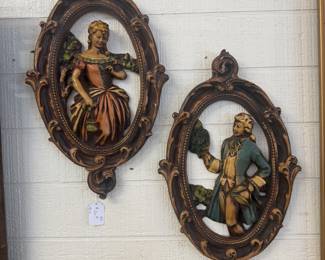 Vintage Colonial couple  wall plaques 1950s featuring 3D relief figures of a lady & gentleman in 18th century style attire hand painted with ornate oval frames 