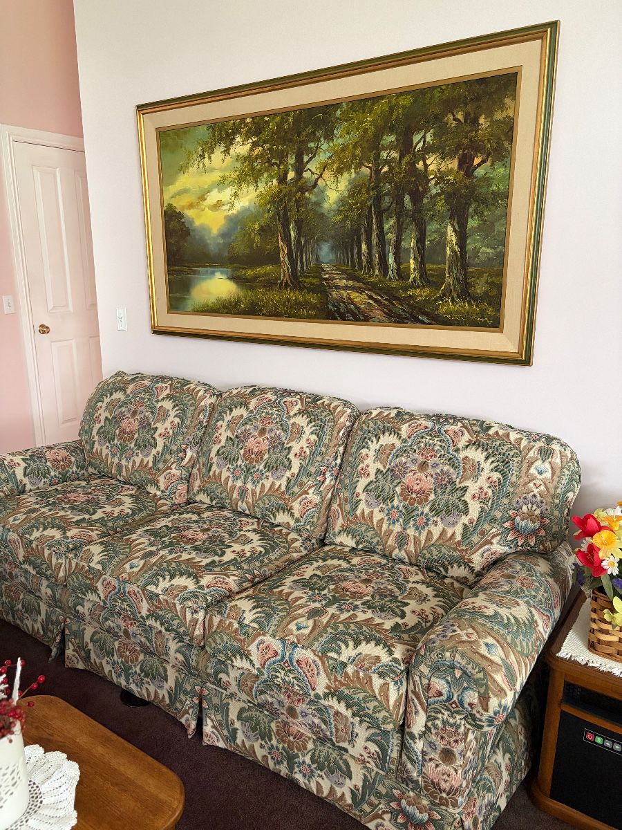 Floral upholstered couch, artwork 