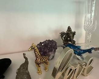 Assorted Decorative Figurines including GoldToned Giraffe, Metallic Elephant, Blue Whale, Silver Love Sculpture, Ganesha Statue, and Crystal Champagne Flute