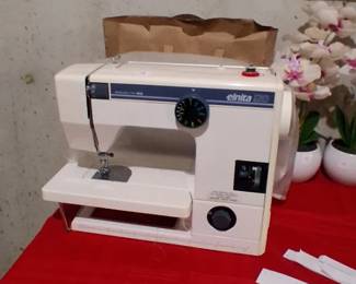 white Elna Elnita 120 portable sewing machine featuring blue branding.