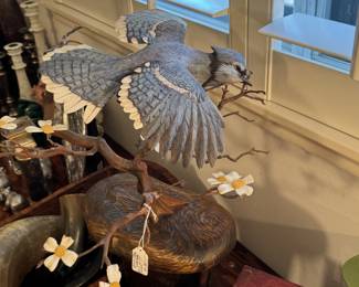 Finely carved ultra realistic sculpture of a Blue Jay on natural wood stand