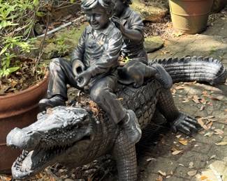 Lifesize amusing garden sculpture of 2 children riding an alligator