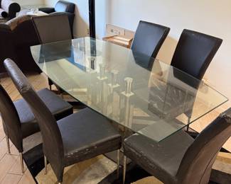 Beautiful glass dining room table with unique glass base.   Six chairs need to be  upholstered.   Table  71 in L x 40 in W x 29.5 in H Chairs 18in L x 18.5 in W x 40 in H