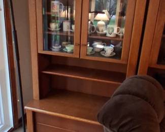 light oak or pine two-piece display cabinet hutch, featuring upper glass doors for showcasing items and a lower enclosed storage section.