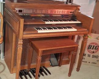 vintage Lowrey electronic home organ featuring dual keyboards and a wooden cabinet