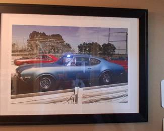framed photograph showcases a blue 1969 Oldsmobile 442 racing on a drag strip.