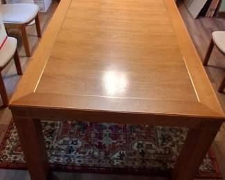 light oak dining table features a clean, rectangular design with a thick-rimmed top
