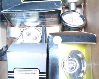 vintage automotive instruments, including a Stewart Warner brand vacuum gauge and a tachometer.