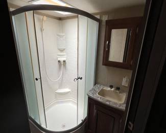 Has a full bathroom with a shower, toilet and sink.