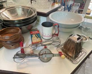 Vintage Kitchen Gadgets Assortment: Egg Beaters, Grater, Bowls, Juicer, and Cream Extractor Tin