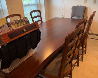 High-end dining table with substantial presence and eight chairs beautiful piece original cost 15,000. We are taking the best and highest.