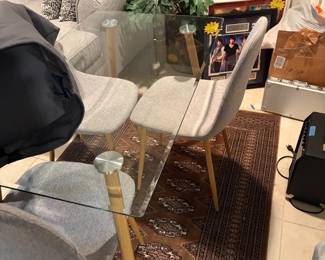 Glass table and four grey upholstered chairs great look 