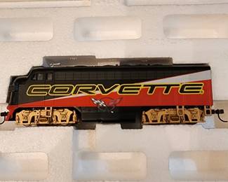 This photograph shows a Hawthorne Village HO scale model train car painted in a red, black, and gold scheme with the word "CORVETTE" and a checkered flag emblem