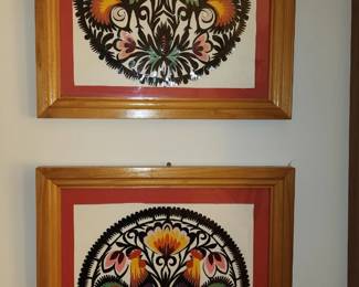 Polish folk art pieces, each featuring intricate cut-paper designs with vibrant colors and symmetrical floral motifs