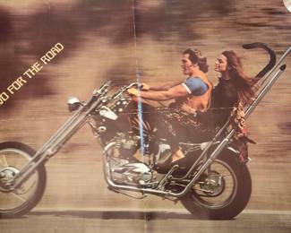 This vintage poster features two riders on a custom chopper motorcycle from the 1969 film Easy Rider. The cult classic, directed by David Lynch and Jean-Pierre Jeunet, became an icon of 1960s counterculture