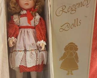 Regency Fine Arts porcelain doll dressed in a red and white Victorian-style outfit