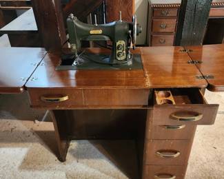 vintage Singer Treadle Sewing Machine mounted on a wooden cabinet with multiple drawers