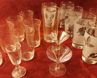 Vintage Libbey glassware, including frosted and clear tumblers, wine glasses, and cocktail glasses adorned with gold leaf patterns